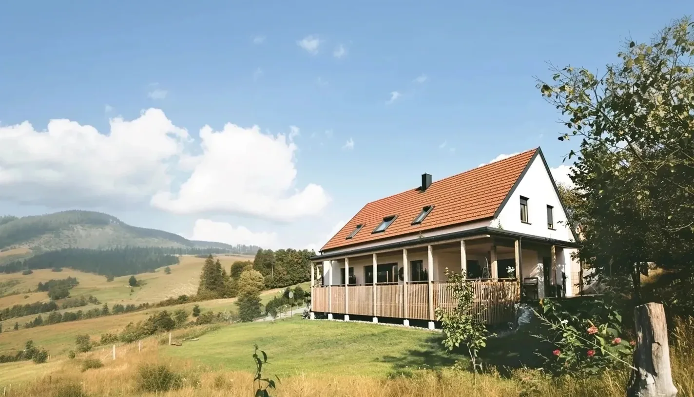Naturhaus mit Holzveranda in der hügeligen Landschaft des Wechsellandes