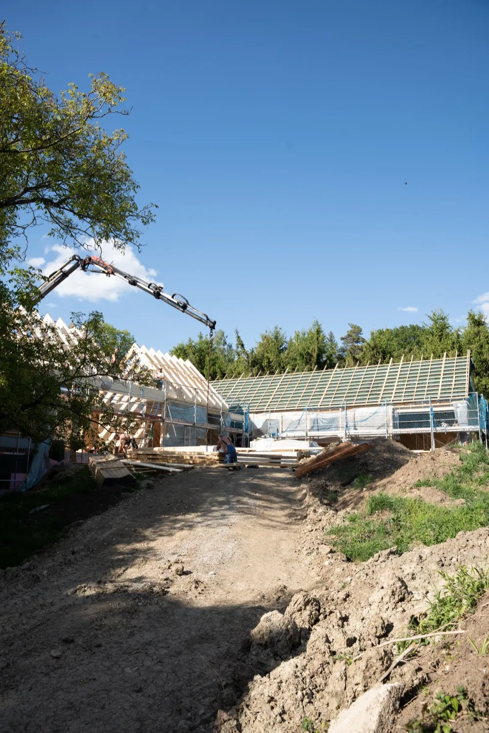 Baustelle eines Strohballenhauses mit Kran und Dachstuhl in der Steiermark