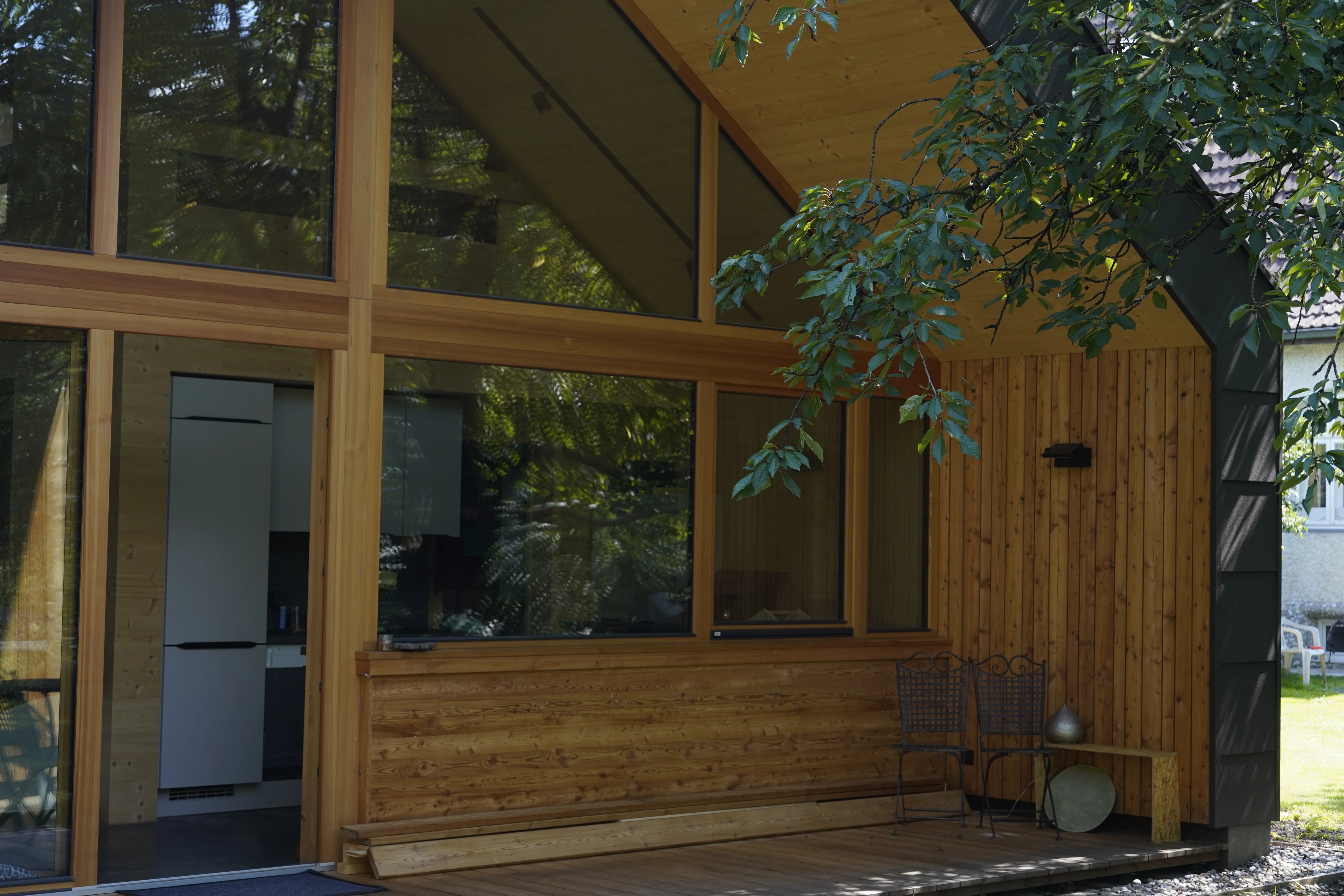 Büro David: Terrassenbereich mit Holzschalung und raumhoher Verglasung