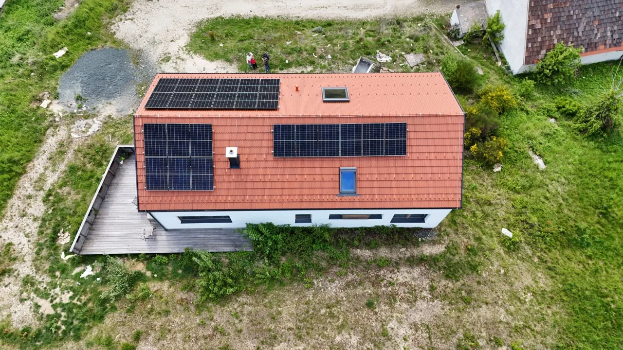 Haus Antonia: senkrechte Draufsicht auf das Satteldach mit Photovoltaik und die Holzterrasse