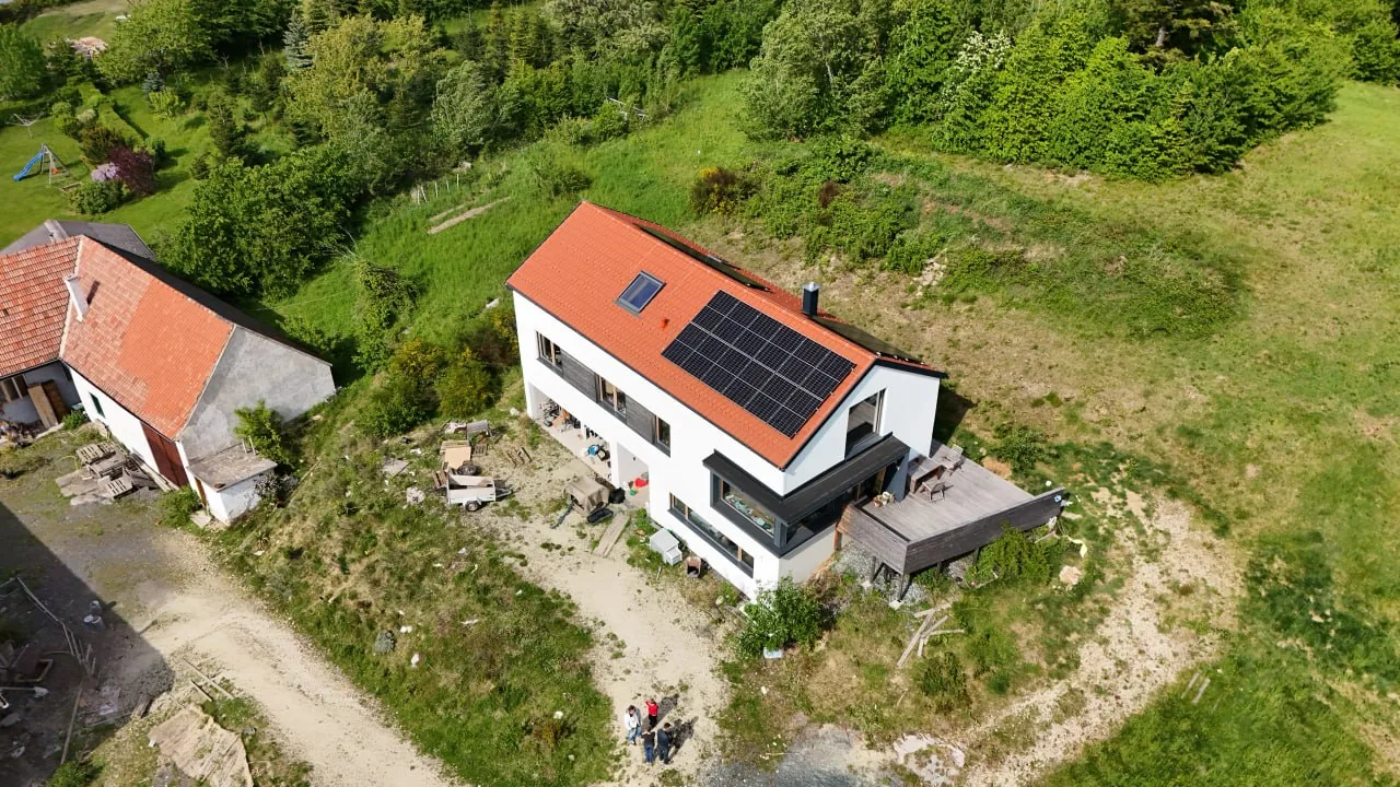 Haus Antonia: Luftbild von schräg oben, dunkler Erker im Erdgeschoss und Holzterrasse an der Giebelseite
