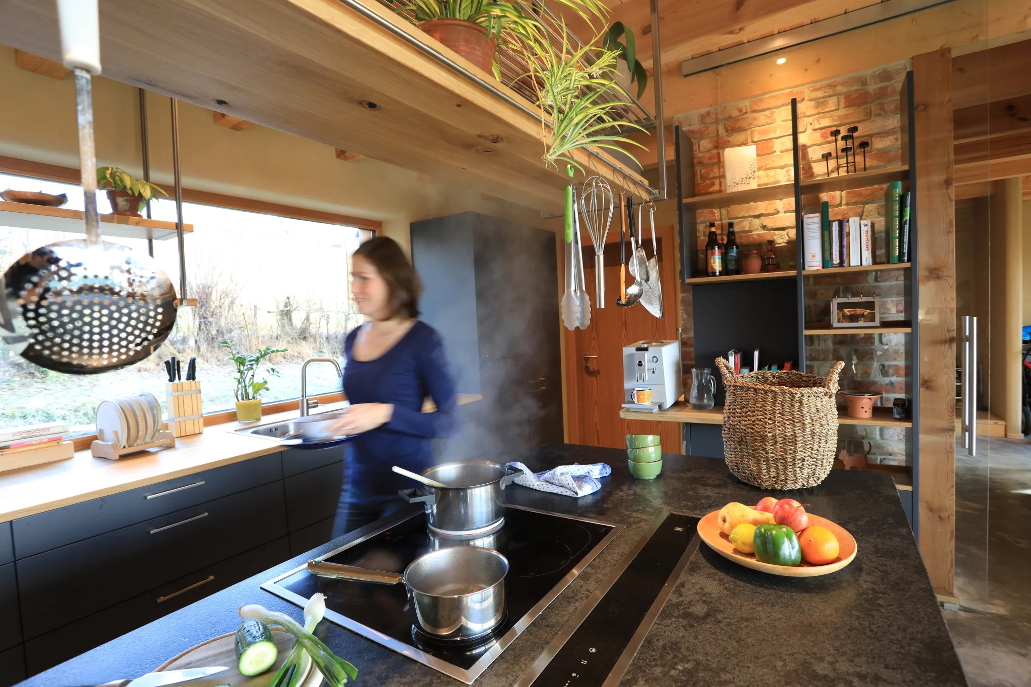 Haus Monika: Offene Küche mit Holzdecke und warmen, natürlichen Materialien