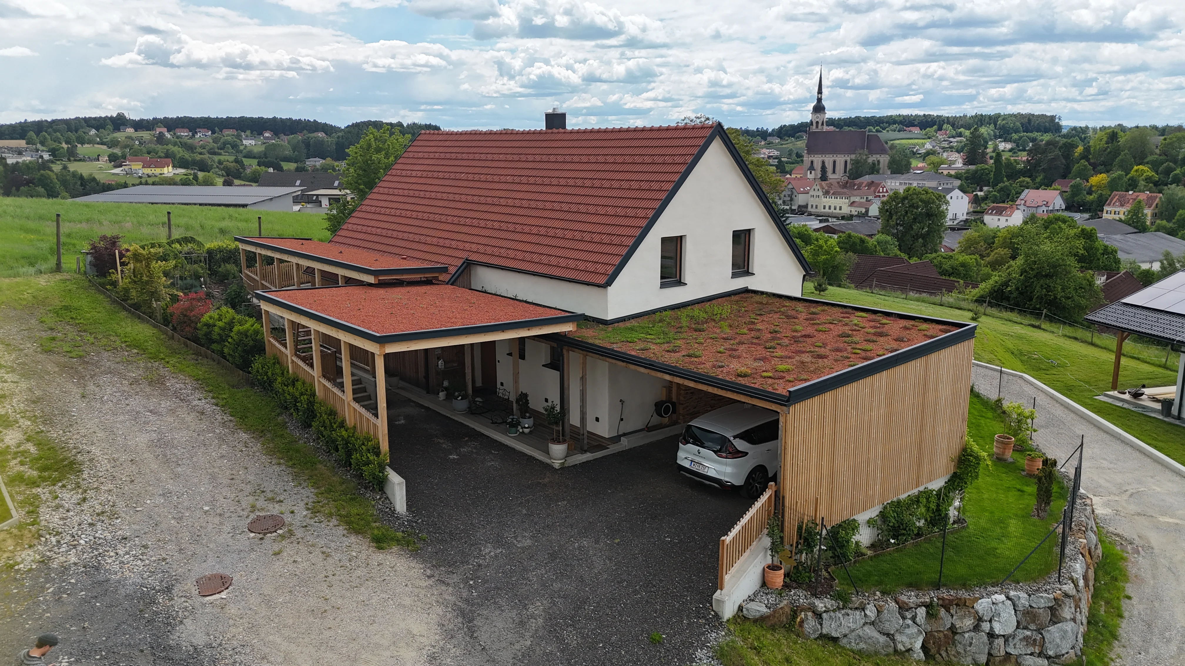Haus Renate: Luftaufnahme des Gesamtensembles mit begrüntem Dach, Holzfassade und Pergola