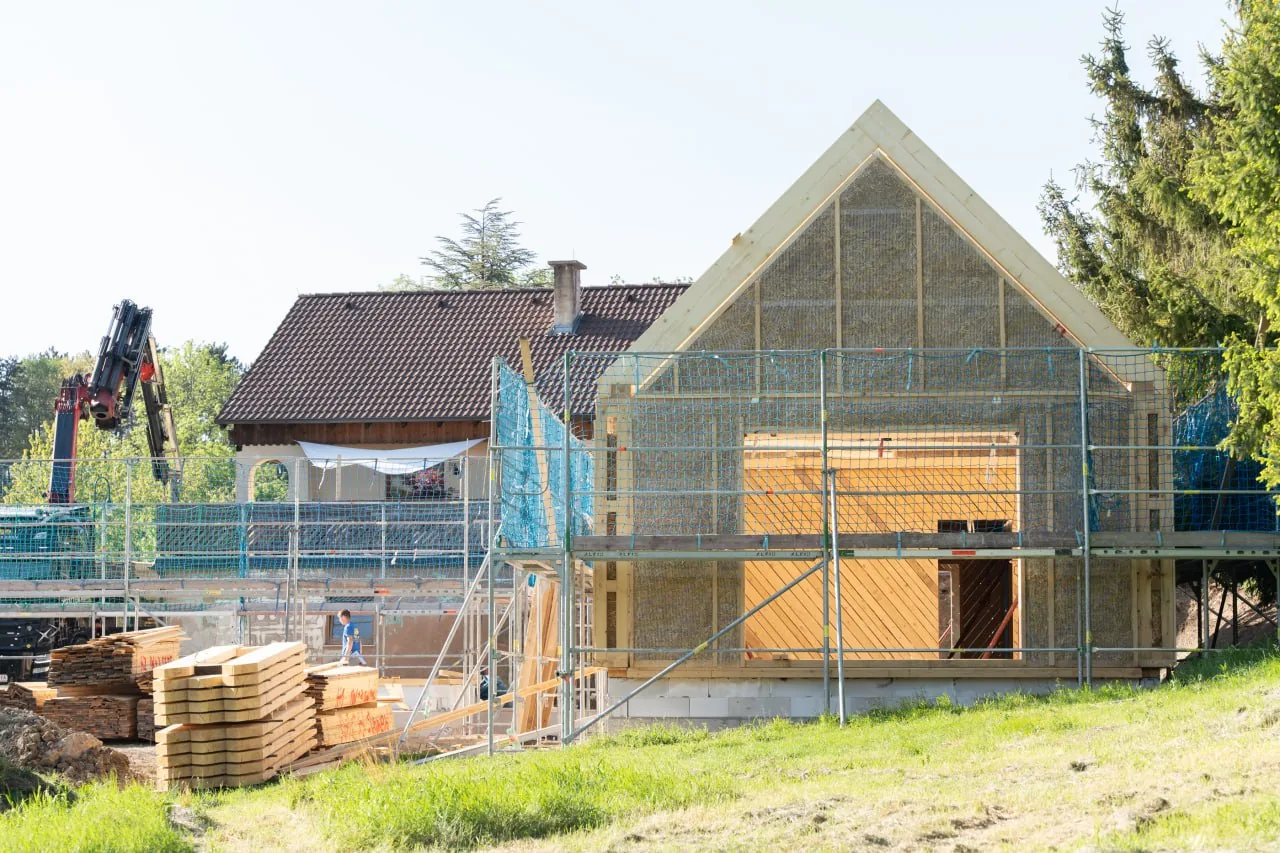Projekt Lauber: Giebelwand im Rohbau, das Holzständerwerk ist mit Strohballen ausgefacht, davor das Gerüst