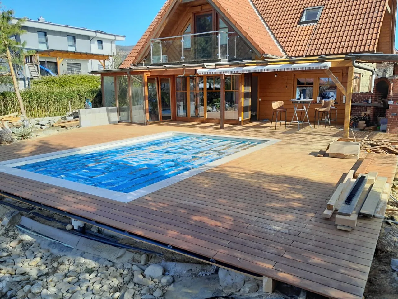 Gesamtansicht der fertigen Holzterrasse, die den Pool auf allen Seiten umschließt
